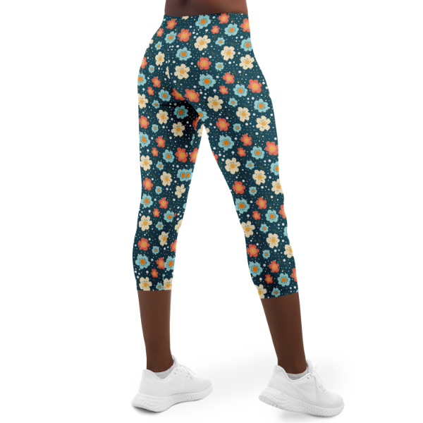 Blue Flower Power Capri Leggings on a model yellow blue orange flowers on a dark blue background