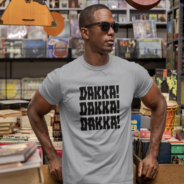Young man wearing sunglasses wearing an Ork Dakka Tshirt in Light Grey