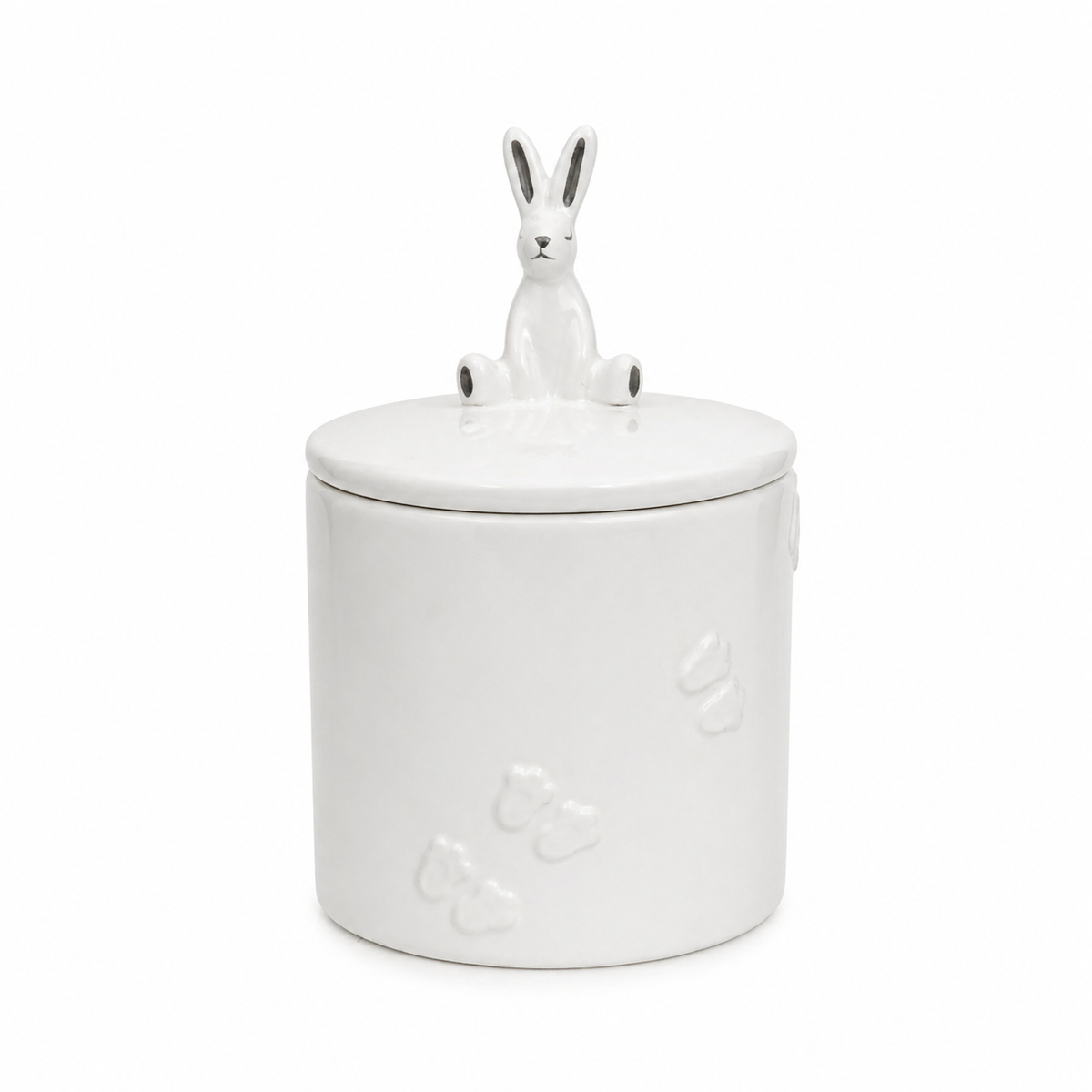 studio image on white of the glossy white ceramic rabbit on the trinket jar lid, showing its long ears, dark facial details and seated shape.