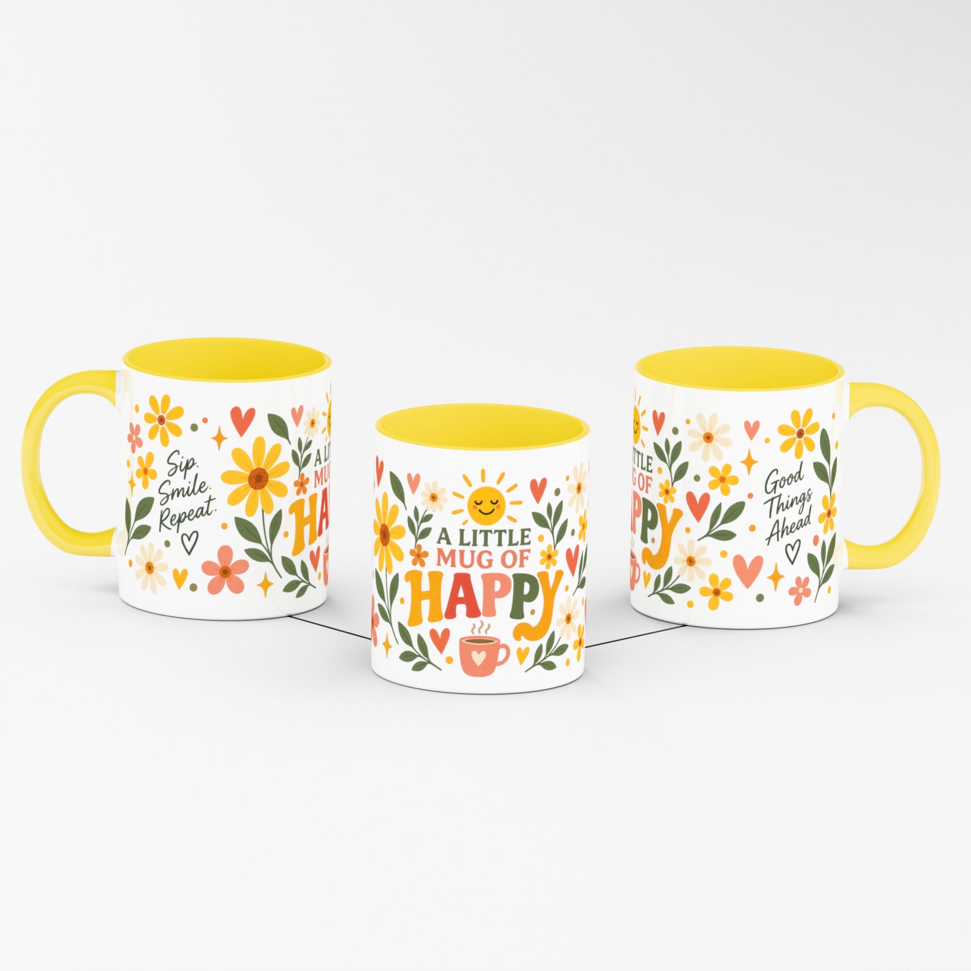 Three white ceramic mugs with yellow interiors and handles, decorated with colorful floral and heart patterns and motivational text, shown on a clean white background.