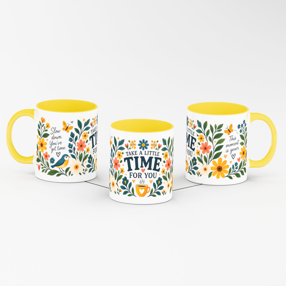 Three white ceramic mugs with yellow interiors and handles, decorated with colorful floral illustrations and the phrase 'TAKE A LITTLE TIME FOR YOU', shown on a clean white background.