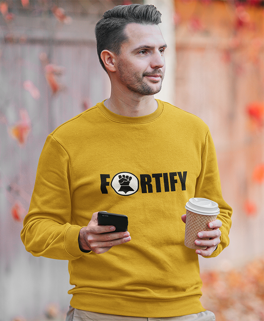 bearded man holding a cup of coffee and his mobile phone weather a fortify gold sweatshirt